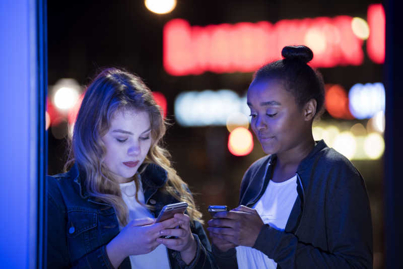 两个年轻的女孩子在看手机
