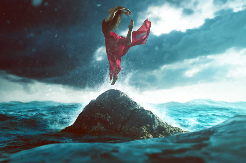 女人在海上的岩石上跳舞