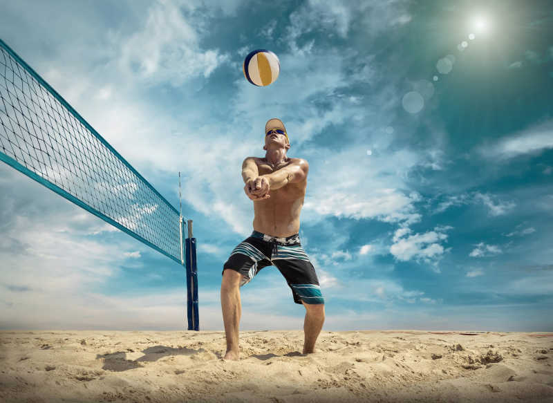 蓝天下在户外玩沙滩排球的运动员