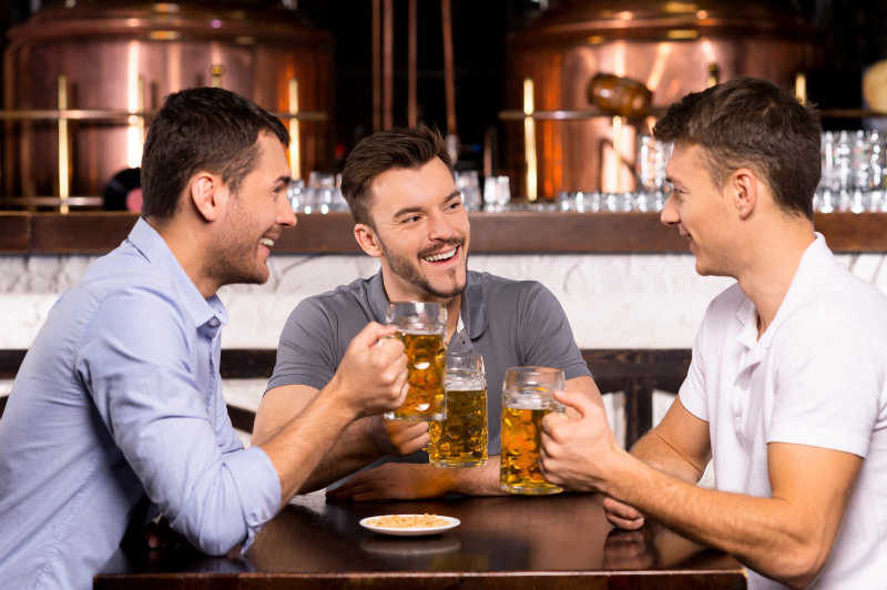 三个成年男人举杯畅饮