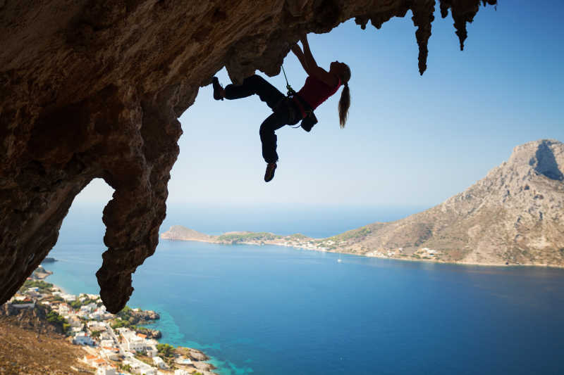 在希腊卡利姆诺斯岛进行攀岩的女性侧影