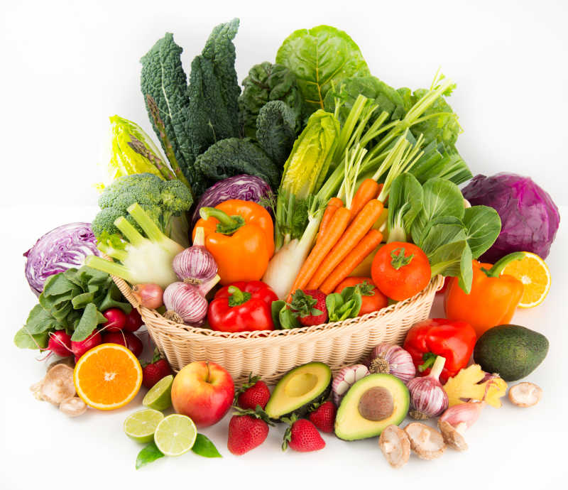 白色背景下篮子里各式新鲜蔬菜和水果