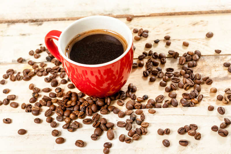 红色咖啡杯里的咖啡和咖啡豆