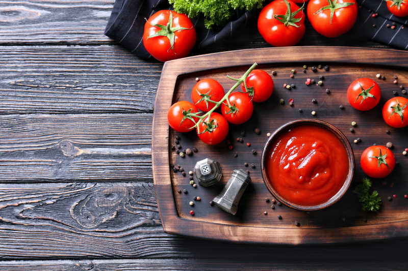 美味的番茄和番茄酱在木制桌子上