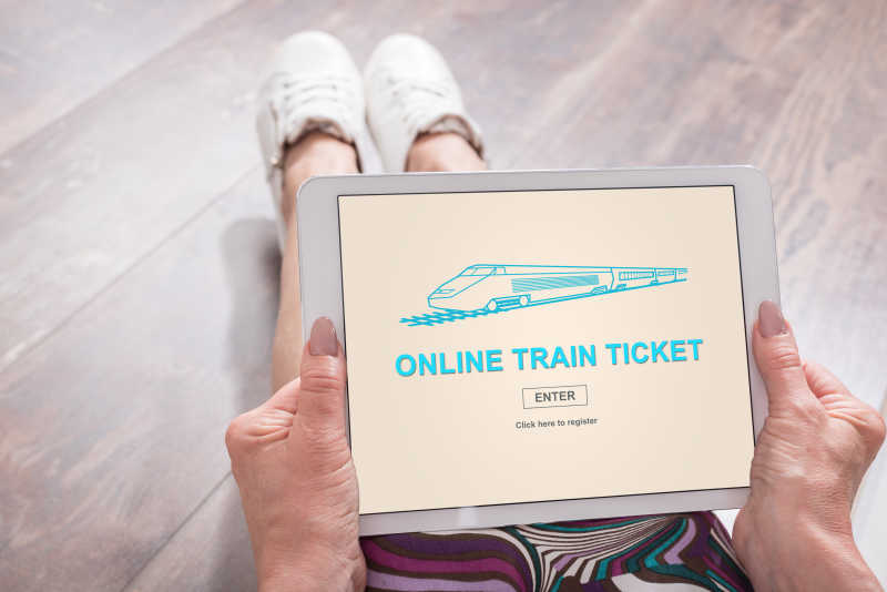 一个人拿着平板在网上购买火车票