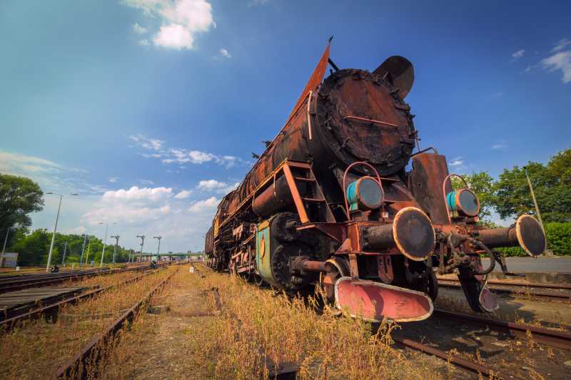 蓝色天空下陈旧的生锈蒸汽火车