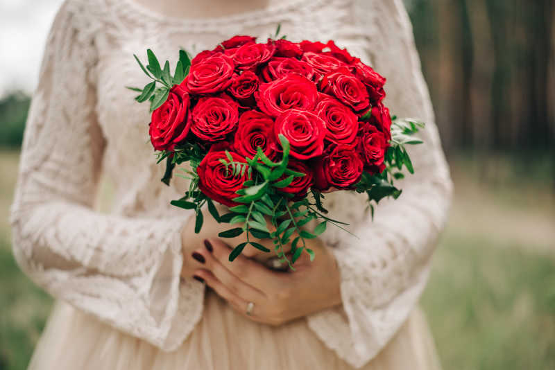 新娘与手里的红色玫瑰捧花
