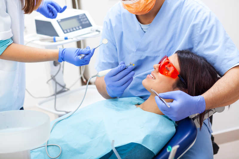 男性牙医检查病人的牙齿
