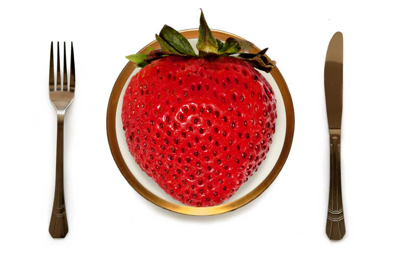 盘子里大大的草莓旁边还准备了刀叉