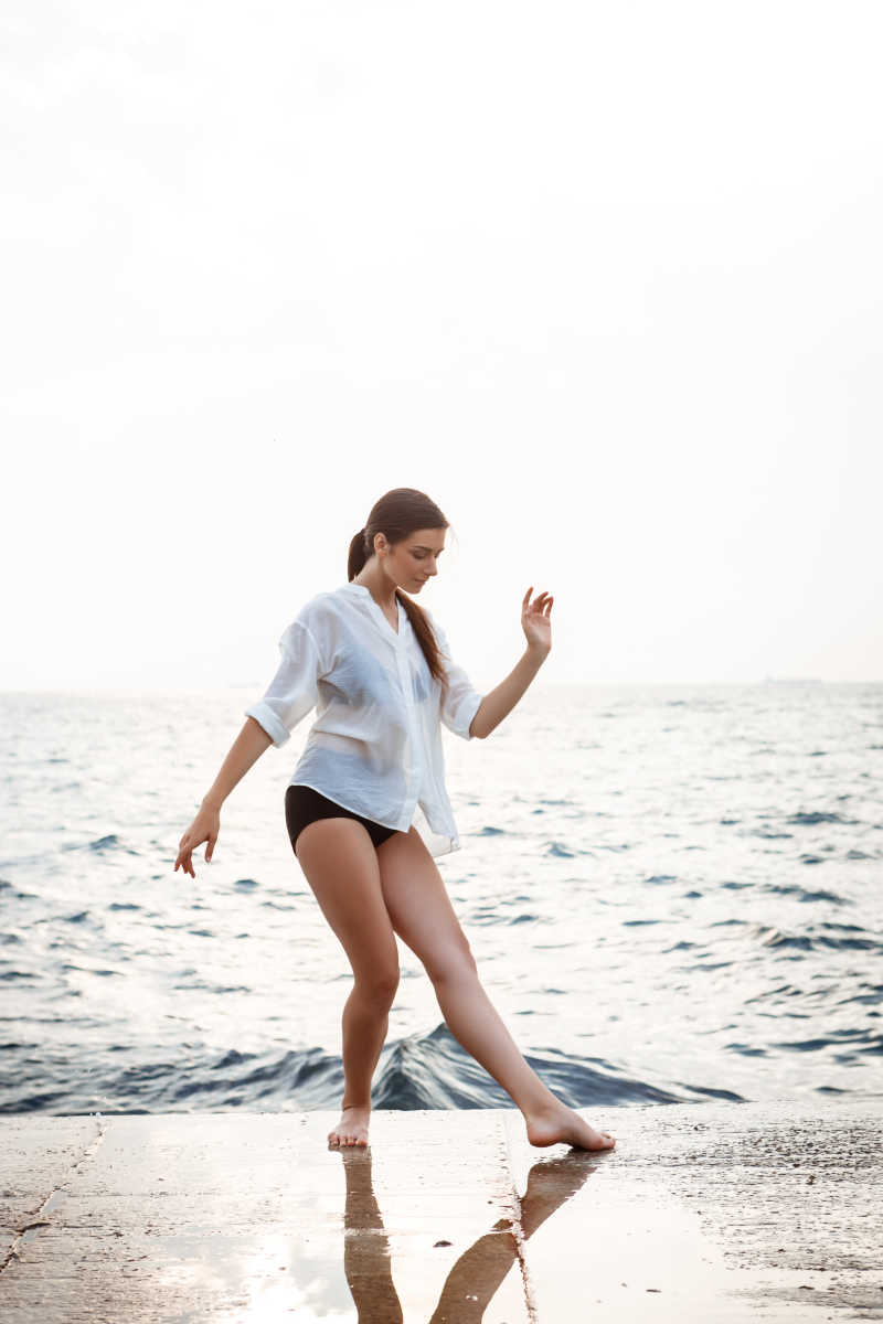 海背景前面的跳芭蕾舞的年轻女子