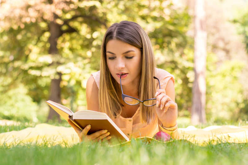 在公园里读书的年轻女子