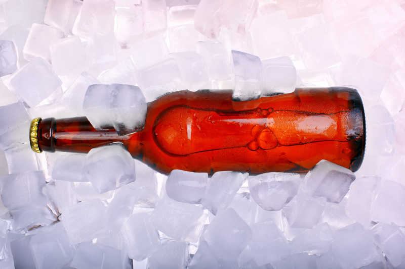冰块上的一瓶红色的啤酒
