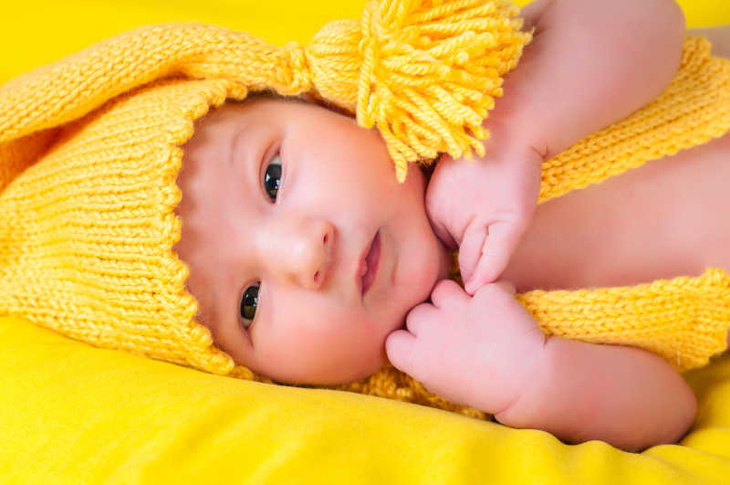 黄色背景穿着黄色衣服可爱的小婴儿