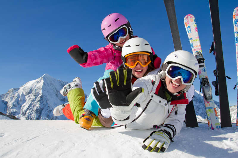 冬季雪山滑雪三个人趴在地上开心的笑着