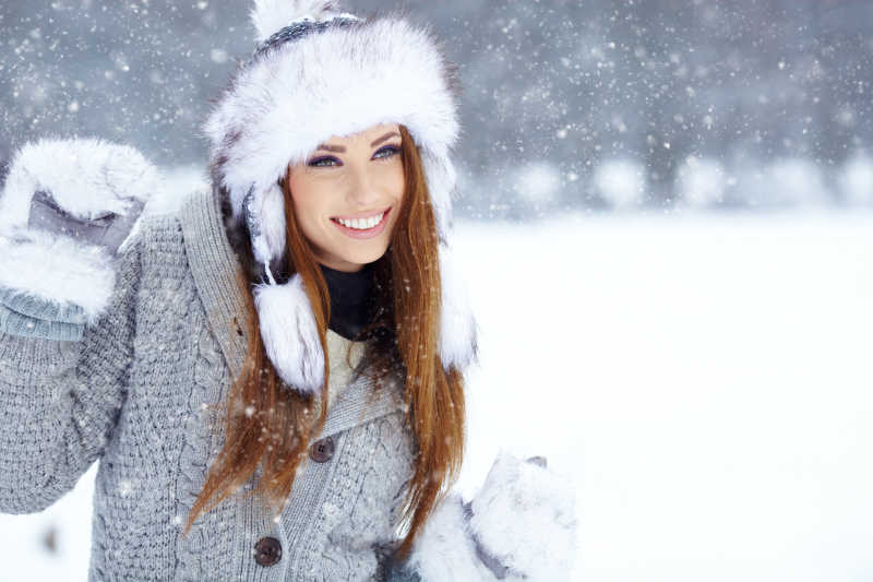 浅色背景年轻女子冬季雪天肖像