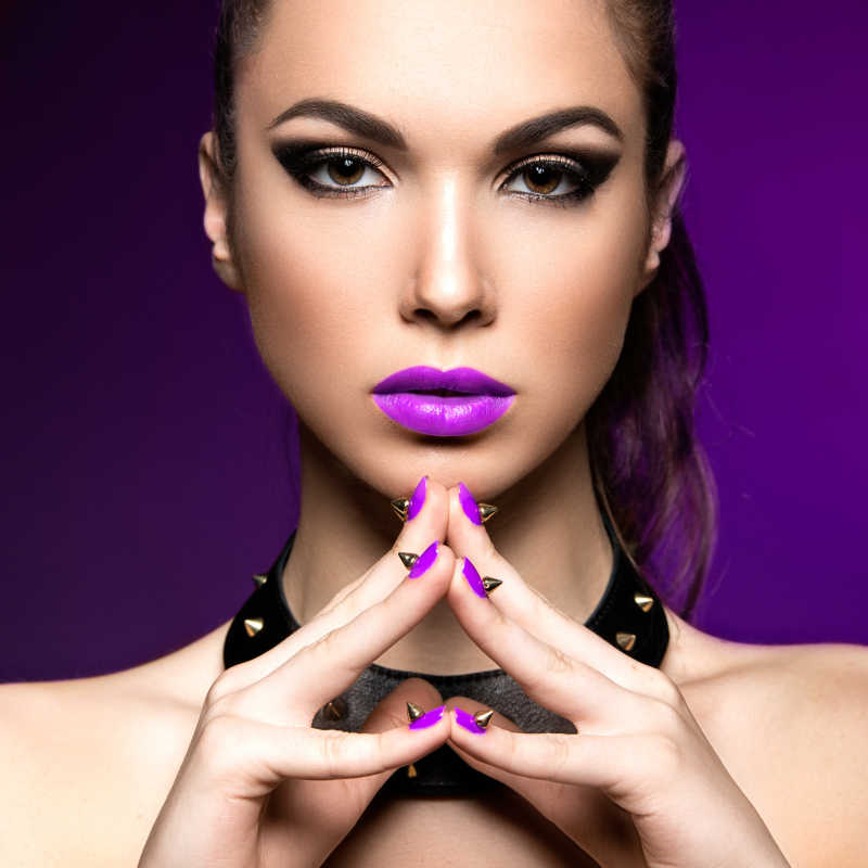 紫色口红和紫色美甲的时尚彩妆模特