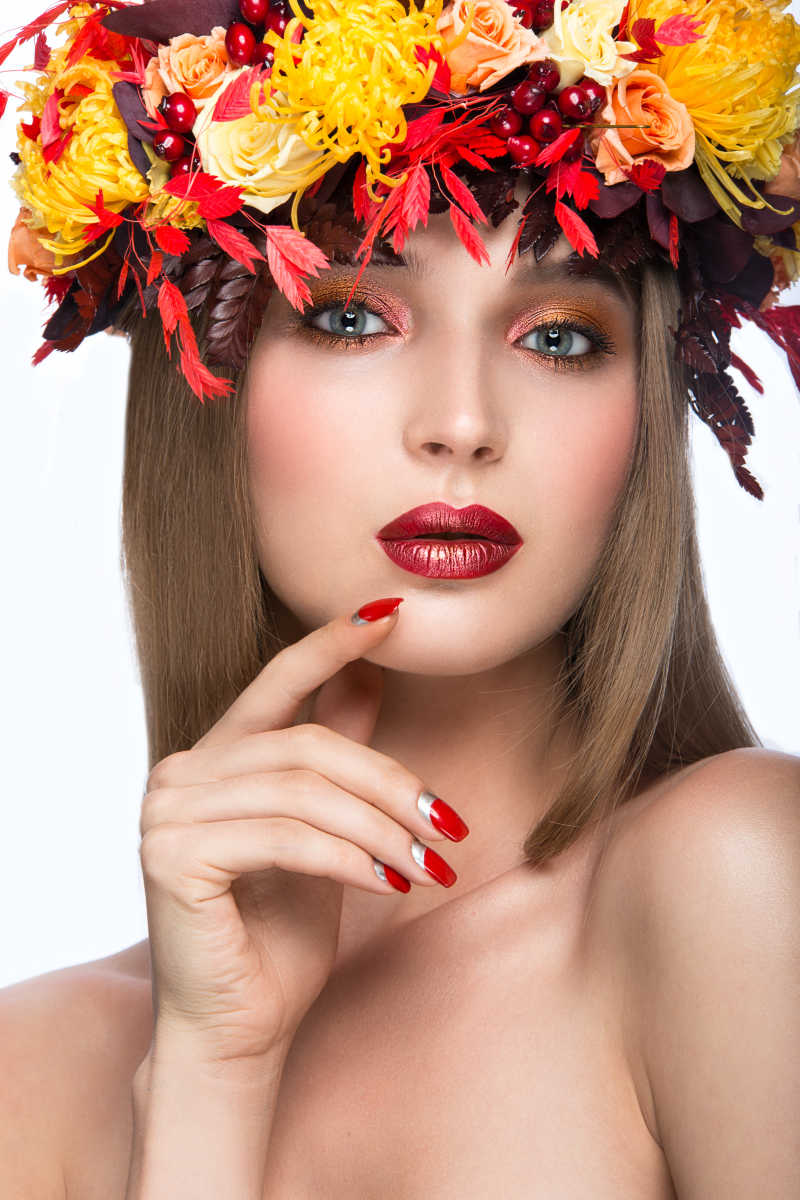 明亮的秋天花环叶子和花组成以及时尚妆容的时尚彩妆