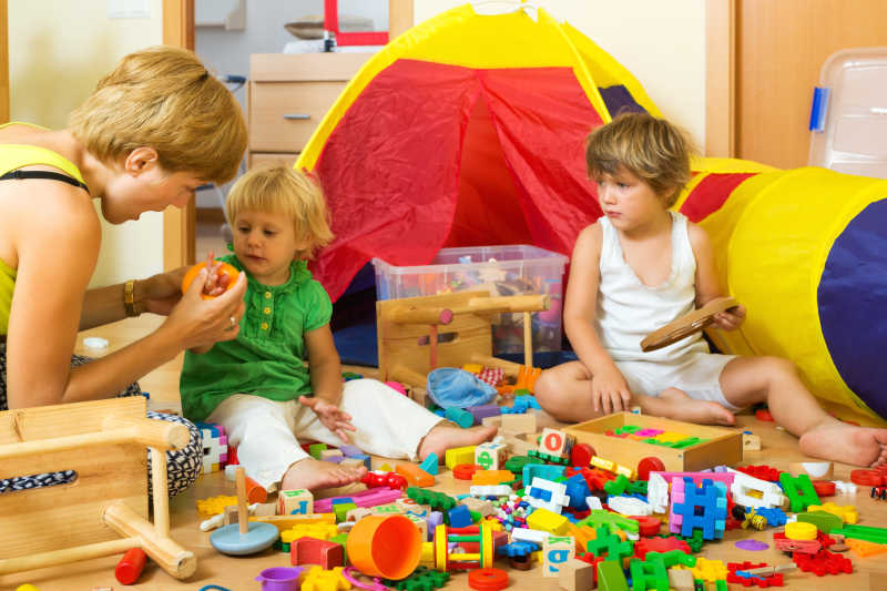 母亲和两个孩子在一起玩积木玩具