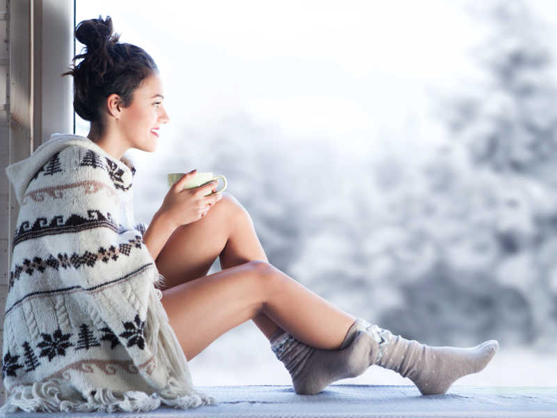 年轻漂亮的黑发女人坐在家门口喝杯咖啡