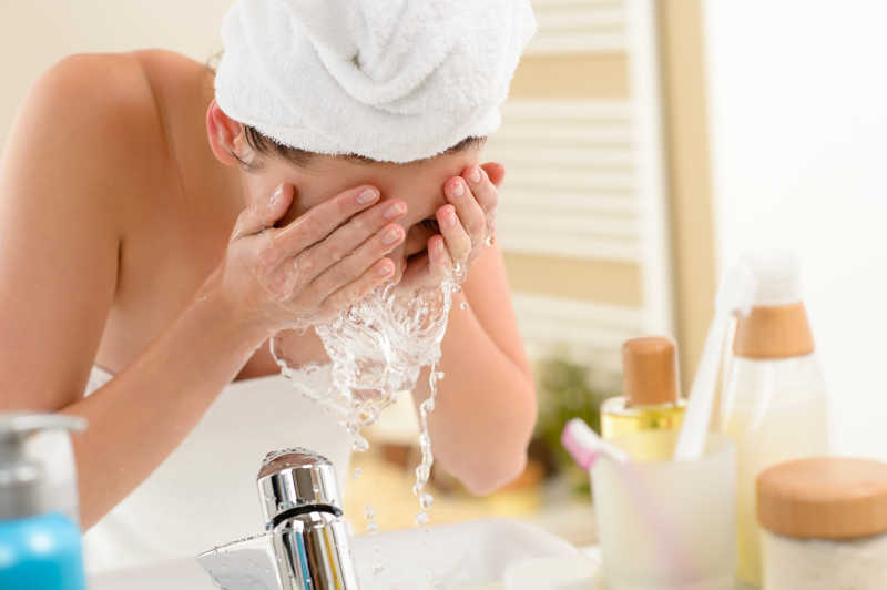 女人在浴室里用泼水洗脸