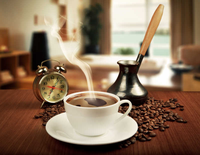 热咖啡杯咖啡豆和闹钟