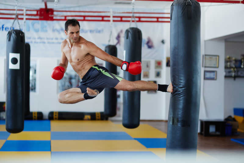 拳击运动员利用拳击袋训练侧踢