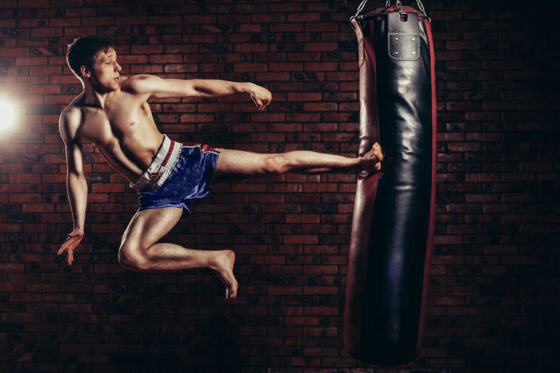 运动员有力踢向拳击袋练习跆拳道