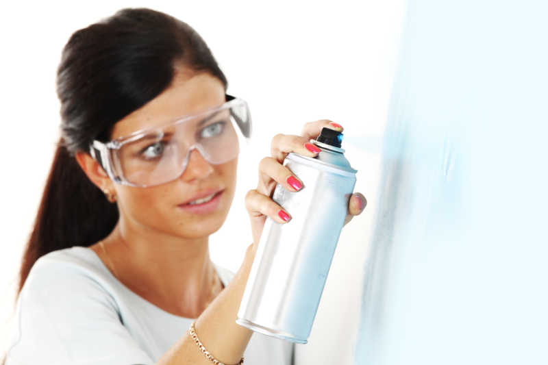 女人使用喷剂油漆喷墙