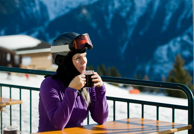滑完雪坐着喝咖啡休息的美女