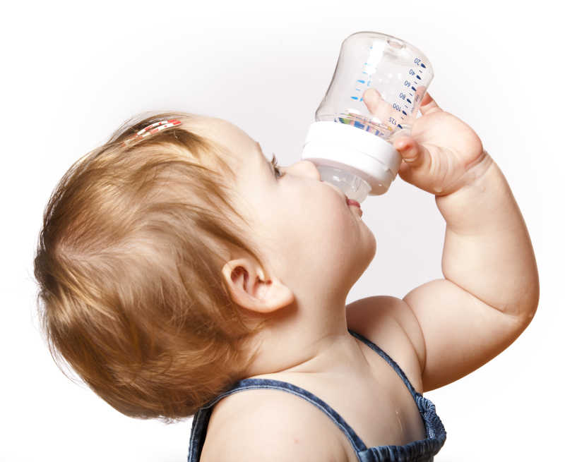 婴儿拿着奶瓶喝水