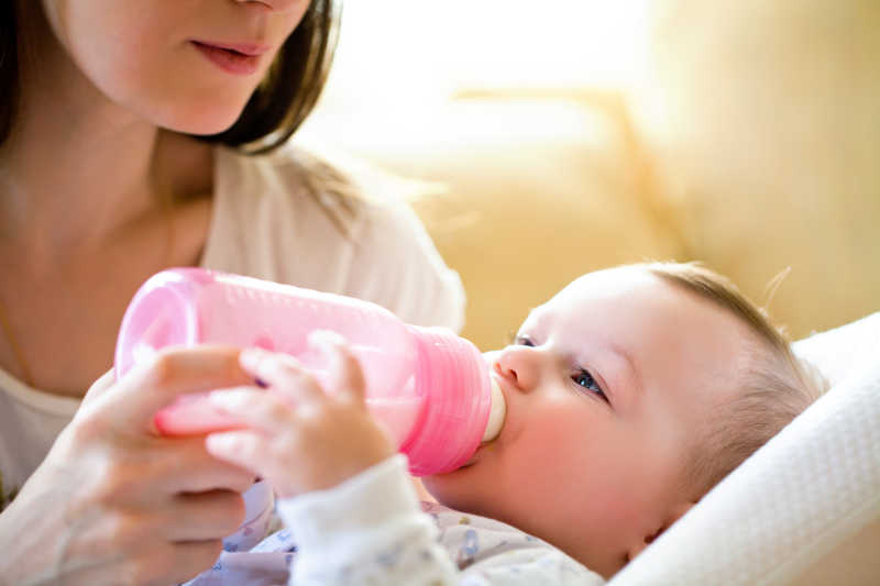 妈妈用奶瓶喂宝宝和奶粉
