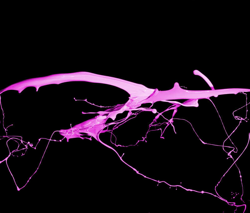 黑色背景下的粉红色油漆飞溅