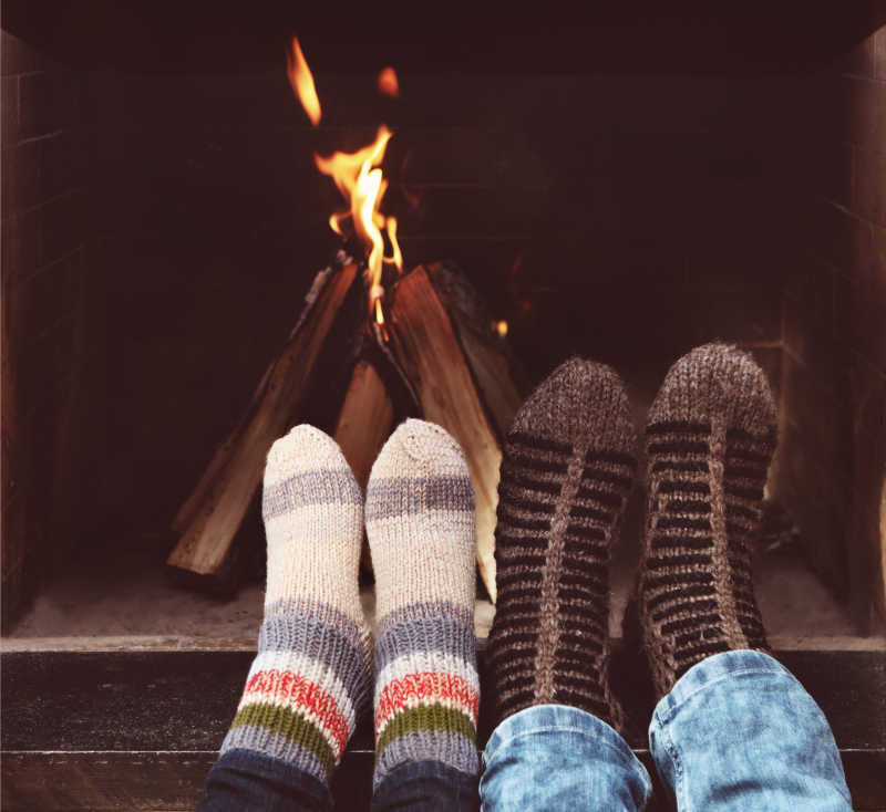 在壁炉前用袜子围上一对情侣的浪漫腿