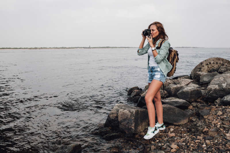 海边岩石上的女孩摄影