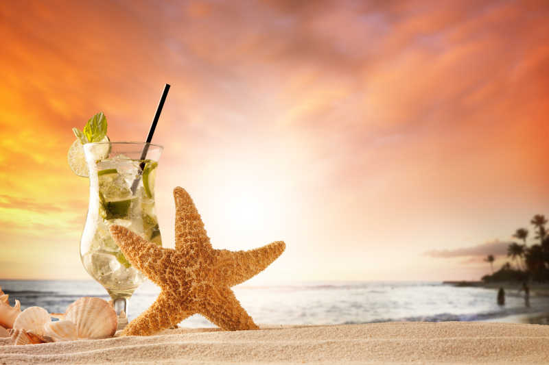 落日下假日海滩海星贝壳和香槟