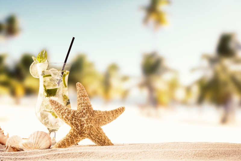 夏日海滩一本带着柠檬的饮料和海星