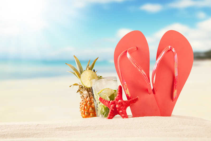 夏日海滩一双红色凉鞋和贝壳