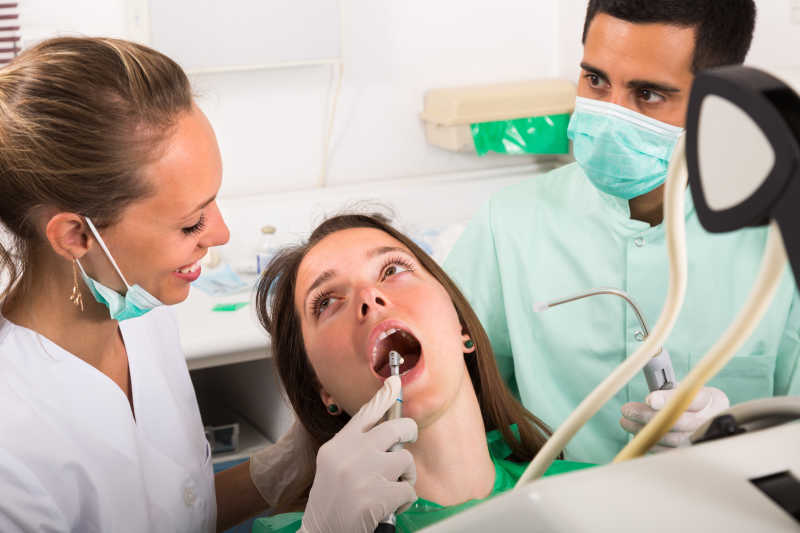 牙医诊断女性患者的口腔