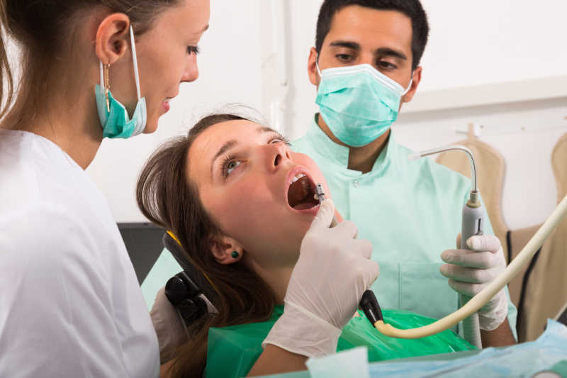 牙科医生在门诊检查年轻女孩的牙齿