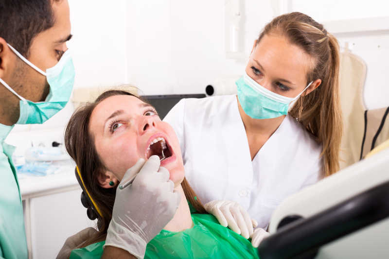 男性牙科医生诊断女性口腔健康