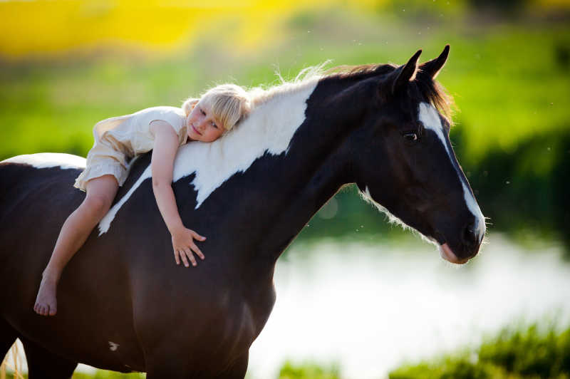 女孩趴在马背上