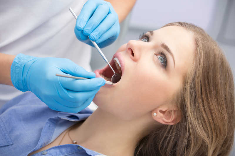 牙科医生帮美女患者检查牙齿