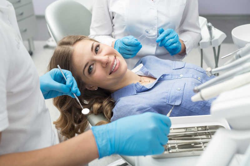 两个牙医帮美女患者检查牙齿