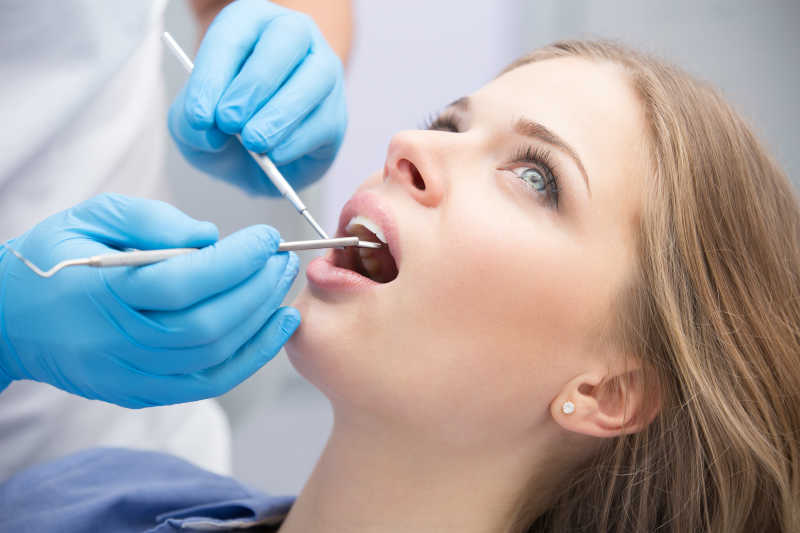 牙医帮美女检查牙齿的特写
