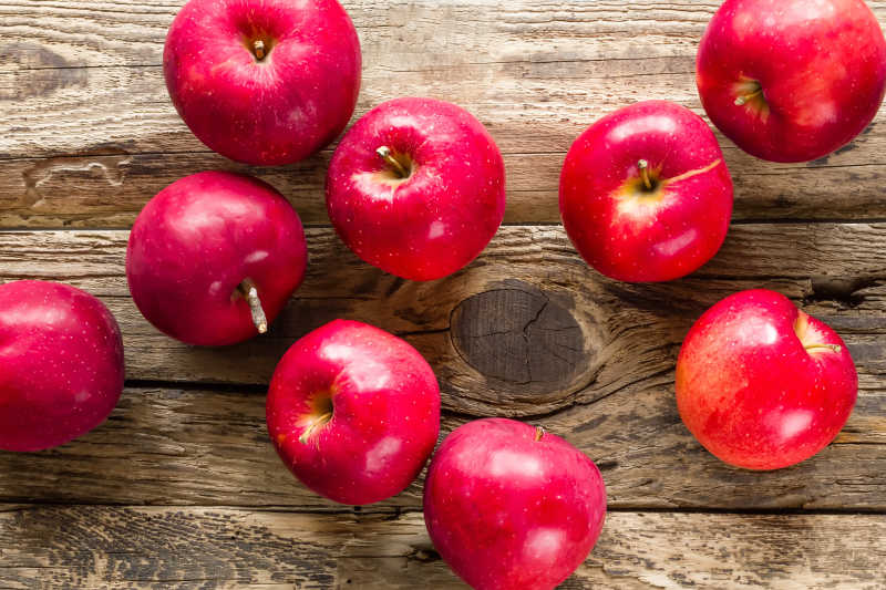 木桌上的散落的红苹果
