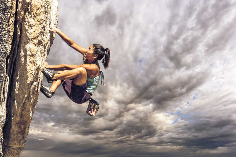 攀登悬崖的女攀岩者挑战极限运动
