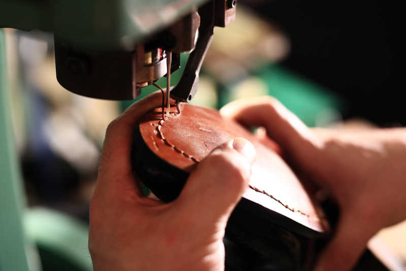 鞋匠利用机器缝鞋底特写