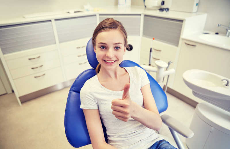 牙诊所里竖起大拇指的小女孩