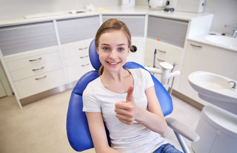 牙科诊所里竖起大拇指的小女孩
