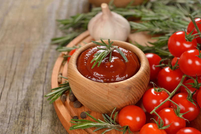 木盘里的新鲜番茄和番茄酱